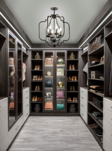 Luxury walk-in closet with custom cabinetry, glass-front shelving, and integrated lighting—finished and styled.