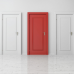 Three finished interior doors installed with casing and hardware—two white and one red accent door.
