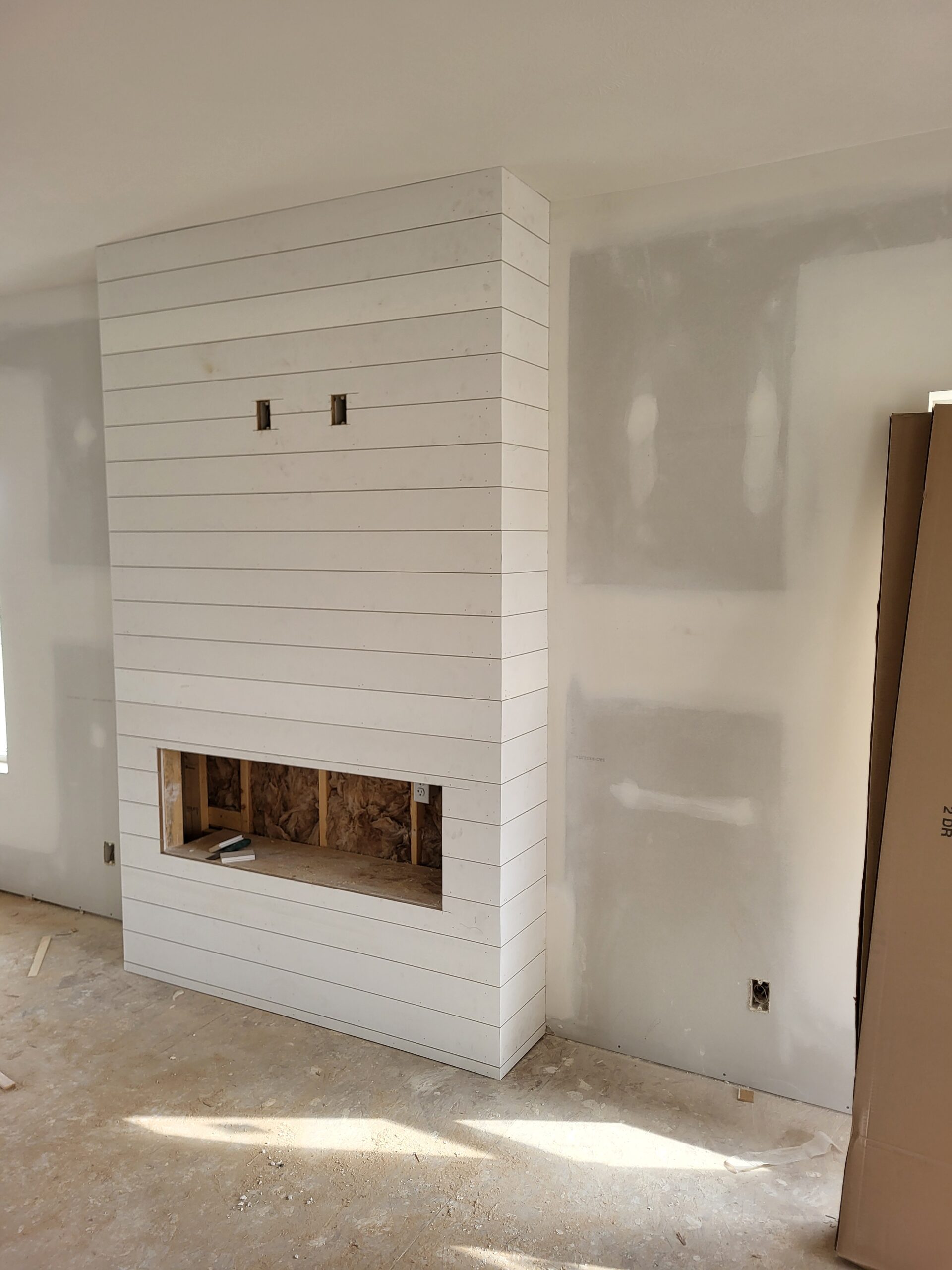 shiplap fireplace — large surround installation in progress showing board alignment and construction details