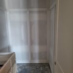 Bypass door frame installed in closet opening with jamb and casing, ready for paint and door slabs.