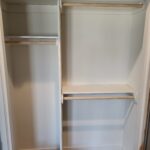 Closet shelving and hanging rod installation with raw wood edges, ready for paint.