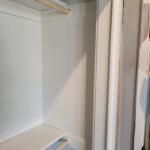 Closet interior with two hanging rods and painted walls, ready for use.