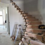 Stair assembly in progress with treads, risers, and clamps during construction phase.