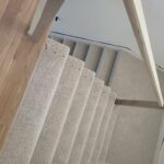 Finished stair risers with carpet covering and white-painted skirt boards installed.