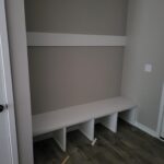Painted face-frame closet shelving with horizontal divider and lower countertop shelf with open cubbies.