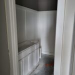 Painted white bathroom or vanity cabinets with finished casing and countertop installed in opening.