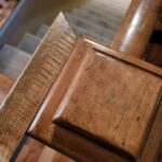 Finished stained wood newel post with rounded profile and polished surface detail.