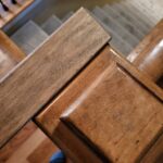 Finished newel post with stained wood and handrail connection at stair landing.