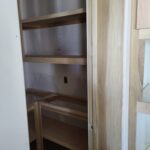 Custom built-in shelving unit with raw wood frame and multiple shelves, ready for finishing.