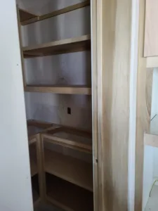 Corner closet shelving framed with raw wood cleats and multiple shelves, ready for finish