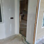 Finished cased opening with white painted jamb and trim, no door slab installed.