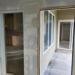 Cased openings with jamb and trim installed, ready for doors or final finishing; drywall work in progress.