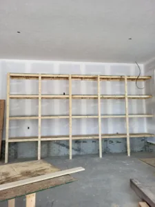 Framing stage closet shelving with raw wood cleats mounted at multiple heights on exposed studs