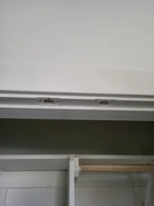 Unfinished closet header with rod brackets mounted, open wall framing visible below.