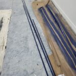 Barn door track sections and connectors staged on floor before installation.