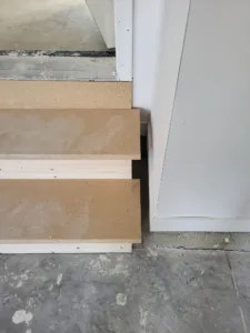 Stacked wood panels staged near a doorway before installation