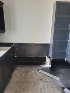 Kitchen or bath cabinetry install in progress, cabinets wrapped in plastic near bare drywall