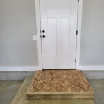 Finished interior door with three-panel slab, painted white, hinges and lockset installed, ready for use.