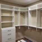 Custom walk-in closet with face-frame cabinetry, shelving, hanging rods, drawers, and integrated LED lighting.