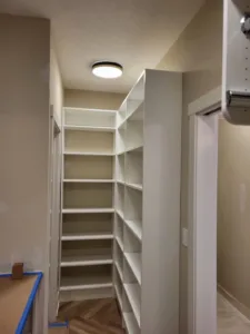 Painted white closet shelving with multiple tiers of open adjustable shelves installed