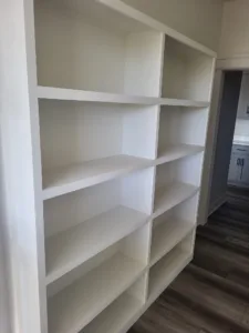 Custom built in shelving with painted white face frame and multiple compartments, ready for storage