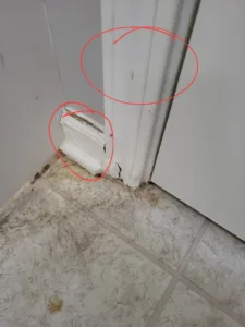 Incorrect: baseboard and door jamb corner split with visible cracks and staining at the floor