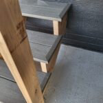 Finished stair risers with gray stain butted to natural wood skirt board, ready for paint.