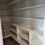 Face-frame closet shelving with multiple tiers, white brackets, and built-in cubby storage boxes—ready for paint.