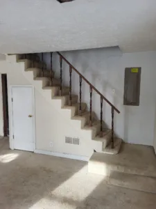 White balusters and dark wood handrail on a carpeted staircase landing.