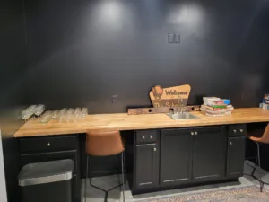 Butcher block countertop on black painted wall cabinetry with hardware installed