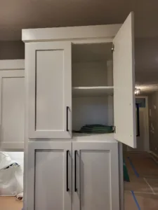 Painted cabinet installation with inset panel doors and interior shelving visible