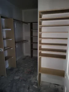 Walk-in closet with a wood-tone shelving tower and multiple hanging rod sections
