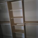 Raw wood closet shelving with five horizontal shelves and vertical supports, ready for paint.