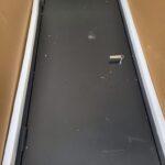 Metal panel cover with frame and mounting hardware, uninstalled in shipping box.