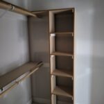 Closet shelving unit with multiple open shelves and hanging rod, raw wood ready for paint.