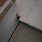 Baseboard meeting floor with gap visible—shoe molding installation in progress or incomplete. (Wrong Way)