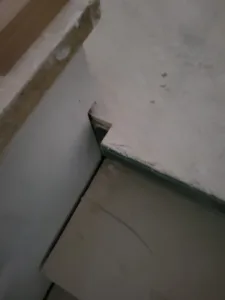 Incorrect: shoe molding corner miter left with a visible gap, unfinished wood at the subfloor.