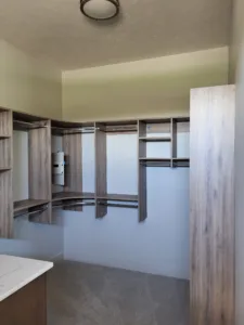 Closet cabinetry with wood-tone shelves, hanging rods, and open storage cubbies installed