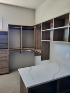 Custom closet shelving with a dark wood-tone finish and open shelving compartments