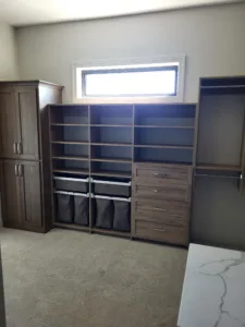 Custom closet built-ins with shelving, storage bins, hanging rods, and a dark wood finish, complete