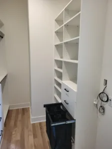 Built-in closet shelving with a painted white finish and open shelves throughout