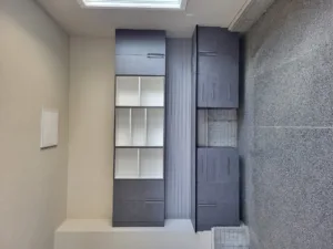 Installed cabinetry with a dark painted finish, glass-front uppers, and metal hardware