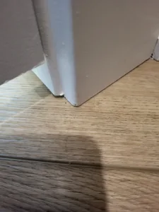 White painted door casing meeting wood flooring at the base, clean finished joint.