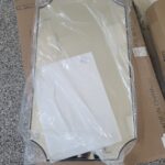 Mirror or glass panel in protective packaging, staged for apartment installation.