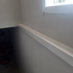 Painted white window sill installed below interior window opening.
