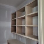 Custom built-in open cubby shelving unit with 3x3 grid compartments and lower shelf, raw wood finish ready for paint.