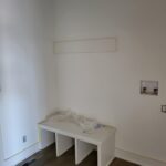 Built-in mudroom bench with open cubby storage compartments, painted white, ready for use.