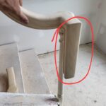 Newel post with decorative profile installed at stair opening, ready for handrail connection.