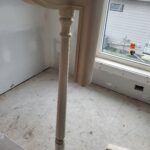 Finished wood newel post with turned details and curved handrail cap, ready for paint or stain.
