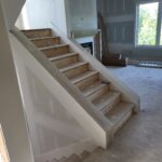 Staircase with finished risers and skirt boards, raw wood treads, ready for paint and stain.